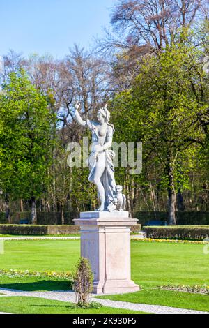 MUNICH, ALLEMAGNE - 20 avril 2015 : statue du Grand parterre (jardin baroque) et vue arrière du palais de Nymphenburg. Munich, Bavière, Allemagne Banque D'Images