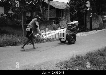 Pangandaran, West Java, Indonésie -17 octobre 2022 : photo noir et blanc, photo monochrome d'un homme poussant un tracteur dans la région de Cikancung, Indonésie Banque D'Images