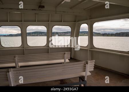 L'intérieur d'un Washington State Ferry avec des fenêtres donnant sur Puget Sound, une communauté de maisons sur l'une des îles San Juan à Washington. Banque D'Images