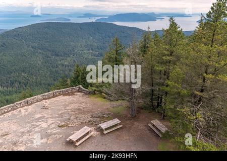 Une vue de quelques-unes des îles de San Juan depuis la tour d'observation au sommet du mont Constitution sur l'île d'Orcas, Washington, États-Unis, avec des bancs de pique-nique dans le for Banque D'Images