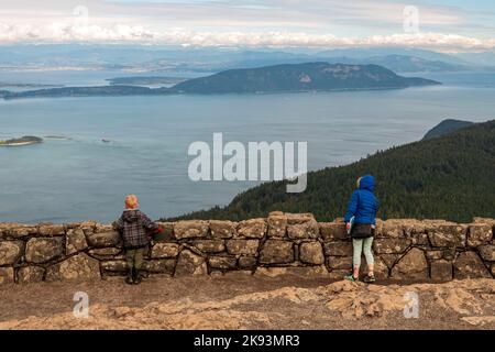 Un jeune garçon et une jeune fille en manteau d'hiver admirent une vue sur les îles de San Juan depuis la tour de surveillance au sommet du mont Constitution sur l'île d'Orcas, Washington, Banque D'Images