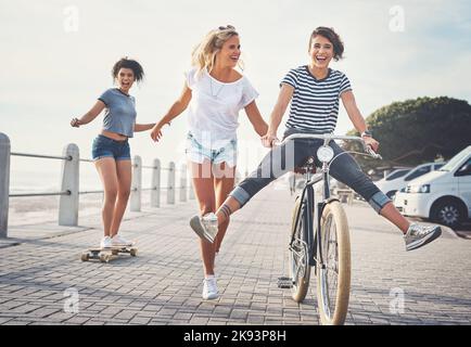 Le plaisir est ce que nous faisons le mieux. Trois amis s'amusent sur la promenade. Banque D'Images