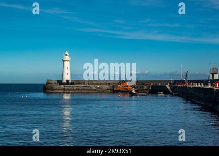 Donaghadee, Comté en bas, Irlande du Nord - 09 mars 2018. Port de Donaghadee avec son phare à l'embouchure avec un canot de sauvetage et un bateau de pêche amarrés Banque D'Images