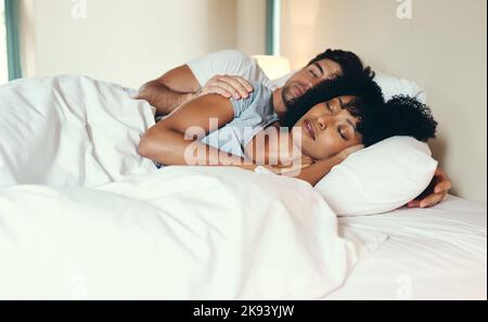 Notre amour se sent comme un rêve qui vient à la vie. Un jeune couple affectueux dormant ensemble paisiblement dans leur lit à la maison. Banque D'Images