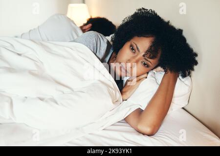 Quelle est la raison de ce mariage : une jeune femme attrayante, couchée avec le dos, a tourné son mari après un argument dans leur chambre. Banque D'Images