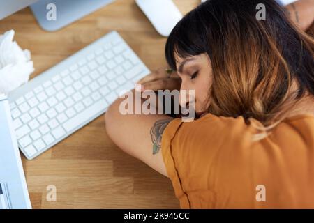 Je pense que mal juste prendre une sieste ici. Une jeune femme d'affaires attirante s'est endormie à son bureau pendant la journée au travail. Banque D'Images