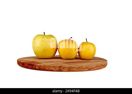Pommes jaunes sur une planche à découper en bois. Ordre de taille des pommes jaunes. Arbre doré délicieux isolé du plus grand au plus petit Banque D'Images