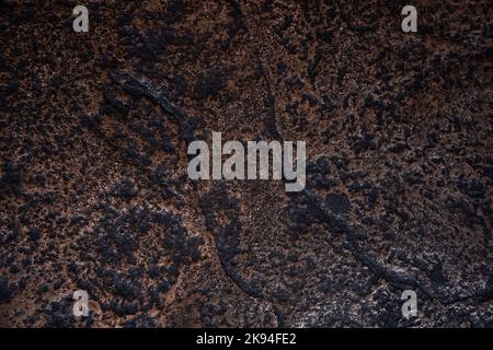 Arrière-plan en pierre sombre dans des tons riches de brun et de noir. Toile de fond texturée à utiliser comme fond de page ou pour ajouter du texte. Banque D'Images