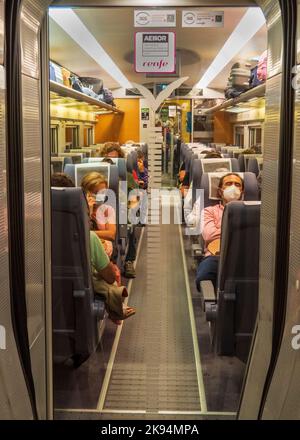 Vue sur un train avec des passagers assis à leur siège à la gare d'Atocha à Madrid. Banque D'Images