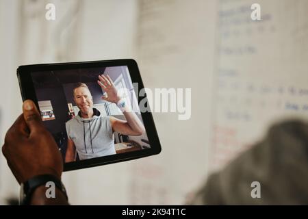 Tablette, salle de sport et coach sur appel vidéo avec l'athlète pour un entraînement en ligne ou d'entraînement. Exercice, formateur technique et formateur personnel discutant avec le client Banque D'Images