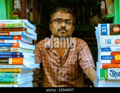 Kolkata, Inde - 9 juillet 2022: Un homme d'âge moyen vendant le livre à l'intérieur d'un petit magasin dans la région de College Street. Banque D'Images