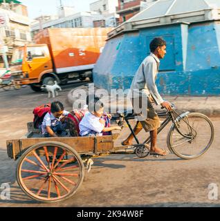 DELHI, INDE - octobre 16 : le père transporte ses enfants le 16 octobre 2012 à Delhi, Inde. Des rickshaws cycliques ont été introduits à Delhi dans les années 1940 Banque D'Images