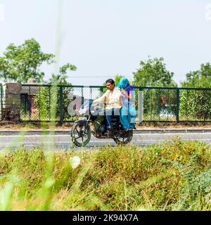 RAJASTHAN - INDE - OCTOBRE 17: Couple de balades en scooter par la route animée sur 17 octobre 2012 dans Rajasthan, Inde. Jusqu'à six membres de la famille Banque D'Images