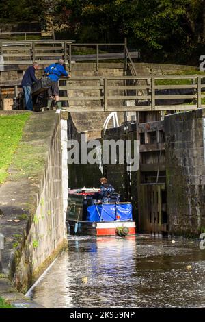 Une barge (bateau à rames, bateau à fond plat) entre dans l'écluse inférieure de cinq écluses à Bingley, dans le Yorkshire, sur le canal de Leeds Liverpool. Banque D'Images