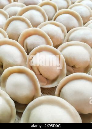 Photo plein cadre de pelmeni de viande. Des rangées de boulettes crues faites à la main, de la cuisine russe traditionnelle. Banque D'Images