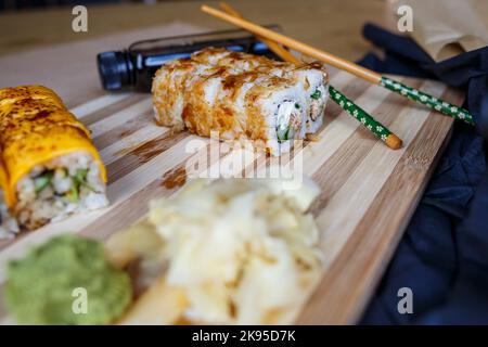 Ensemble de plats japonais traditionnels. Petits pains à sushi, nigiri, saumon cru, riz, fromage à la crème, avocat, gingembre mariné. Banque D'Images