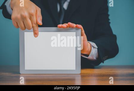 Homme d'affaires tenant et pointant sur une tablette numérique sur le bureau avec un arrière-plan blanc isolé et un espace de copie. Banque D'Images