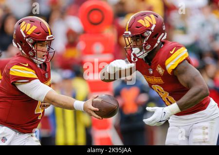 Dimanche, 23 octobre 2022 ; Landover, MD, USA; Washington Commanders Quarterback Taylor Heinicke (4) remet le ballon à la course de retour de Brian Robinson Banque D'Images