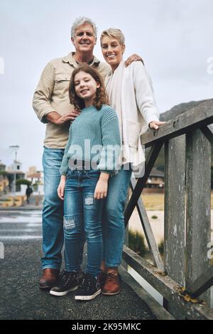 Portrait, enfant et grands-parents sur un pont dans un parc pour l'aventure, la marche et le bonheur ensemble. Heureux, sourire et jeune fille avec senior et Banque D'Images