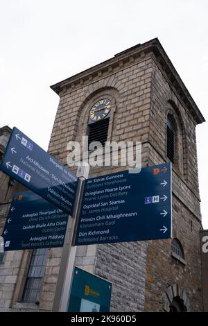 République d'Irlande Eire Dublin Street scène touristique route panneaux signpost anglais gaélique erse St Catherines Eglise horloge tour Banque D'Images
