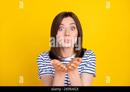 Photo portrait de la charmante coquette adorable jeune fille envoi air baiser porter des vêtements à rayures stylées isolés sur fond jaune Banque D'Images