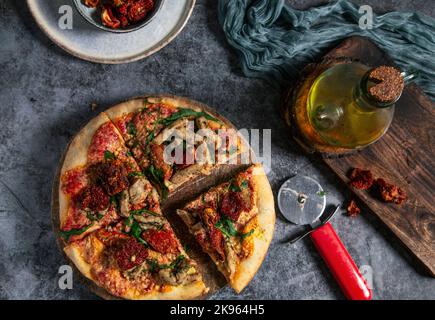 pizza végétalienne faite à la main avec tofu, tomates séchées et arugula en tranches Banque D'Images