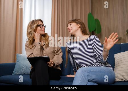 Femme souriante parlant avec un psychologue se sentant positive Banque D'Images