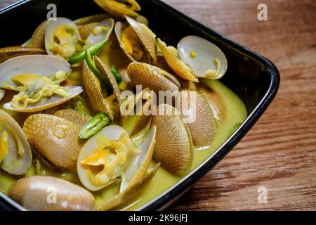 Lala ou palourdes d'eau salée cuites au curry vert et garnies de piments verts. Il a une coque mince avec forme oblongue. Également connu sous le nom de Paphia textile. Banque D'Images