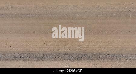 vue de dessus de la surface de la route de gravier faite de petites pierres et de sable avec des traces de pneus de voiture Banque D'Images