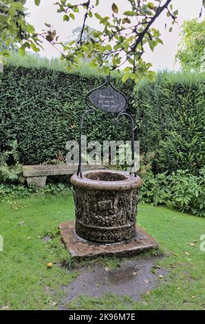 Pierre souhaitant bien et banc dans le jardin Gilbert Whites Hampshire Banque D'Images