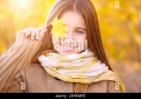 Portrait d'une fille heureuse avec une feuille jaune Banque D'Images