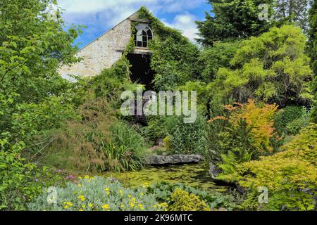 Ancien bâtiment avec étang ornemental planté Banque D'Images