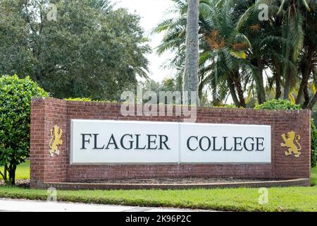 Panneau en brique rouge Flagler College avec deux lions dans un cadre tropical. Banque D'Images