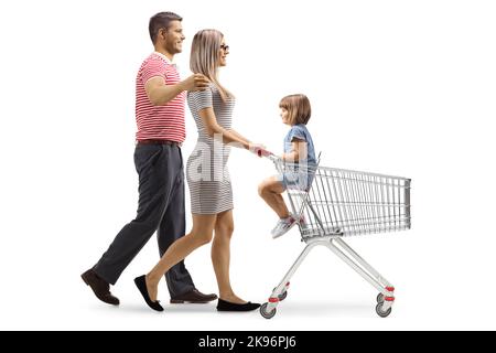 Prise de vue en profil d'un couple poussant un chariot avec son enfant assis isolé sur fond blanc Banque D'Images