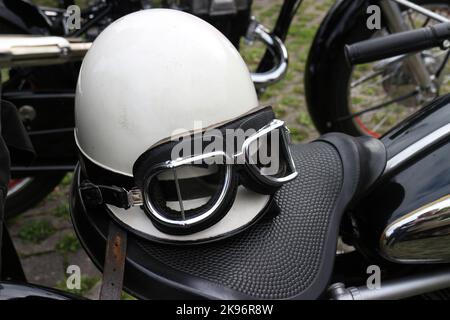 Casque d'accident vintage et lunettes de protection sur le siège de la moto Banque D'Images