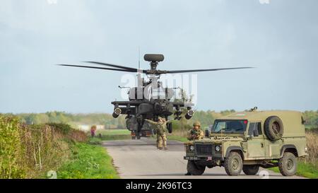 Gros plan de ZM707 hélicoptères d'attaque Boeing Apache de l'armée britannique (AH-64E ArmyAir606) qui décollent après avoir ravitaillé dans une voie de campagne Banque D'Images