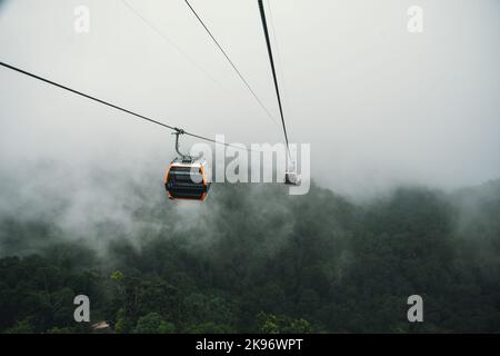 Téléphérique grimpant jusqu'à la colline brumeux au-dessus de la forêt épaisse à Banahill, Danang, Vietnam. Banque D'Images