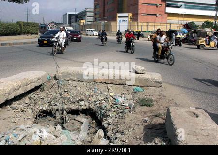 Hyderabad, Pakistan, 26 octobre 2022, les navetteurs passent par un trou principal ouvert qui peut causer tout accident grave montrant la négligence du département concerné, dans la zone industrielle de Korangi à Karachi mercredi, 26 octobre 2022. Banque D'Images