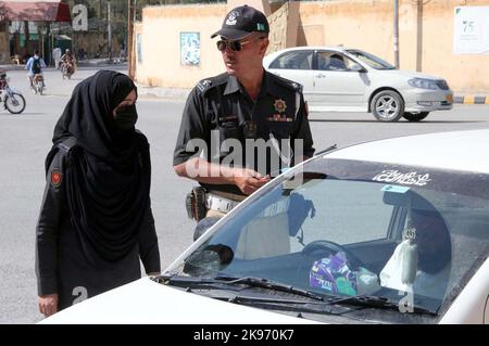 Hyderabad, Pakistan, 26 octobre 2022, les agents de la police de la circulation retirent le film noir de la vitre du véhicule pendant la campagne contre les vitres teintées et les plaques d'immatriculation fantaisie, à Quetta, mercredi, 26 octobre 2022. Banque D'Images