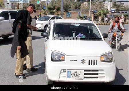 Hyderabad, Pakistan, 26 octobre 2022, les agents de la police de la circulation retirent le film noir de la vitre du véhicule pendant la campagne contre les vitres teintées et les plaques d'immatriculation fantaisie, à Quetta, mercredi, 26 octobre 2022. Banque D'Images