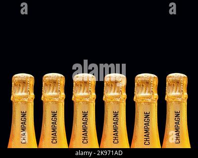 Rangée de bouteilles de champagne recouverte d'une feuille d'or estampillée du mot champagne sur le col sur fond rose Uni. Personne. Copier l'espace. Banque D'Images