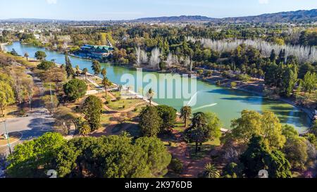 Une vue aérienne du lac et des arbres dans le Parque général San Martin sous le ciel bleu Banque D'Images