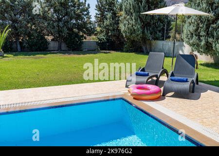 Une piscine et une terrasse avec un donut gonflable Banque D'Images