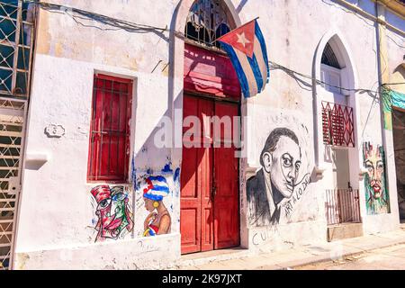 Façade d'un bâtiment aux peintures urbaines et drapeau cubain sur la porte d'entrée Banque D'Images