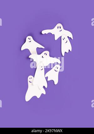 Bannière Halloween avec des fantômes en papier sur fond violet. Banque D'Images