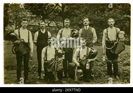 Carte postale originale du début des années 1900 de l'équipe de sauvetage de mines de charbon avec haches et appareil respiratoire de maintien sous forme de casques de fumée Draeger /Drager avec sac respiratoire attaché recouvert d'un rabat en cuir, avec lampes, genouillères de protection et une scie (en premier plan) ils étaient bien équipés pour répondre en cas de catastrophe. Vers 1919, Royaume-Uni Banque D'Images