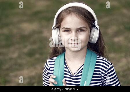 L'anglais est destiné à apprendre. Casque pour enfant de petite taille. École d'anglais. Enseignement des langues. Compétences d'écoute. Nouvelle technologie. Enseignement privé. En ligne Banque D'Images