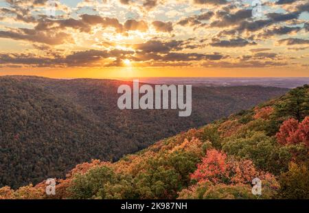 Coucher de soleil derrière les nuages illuminant les couleurs d'automne des arbres dans la forêt nationale de Coopers Rock Banque D'Images