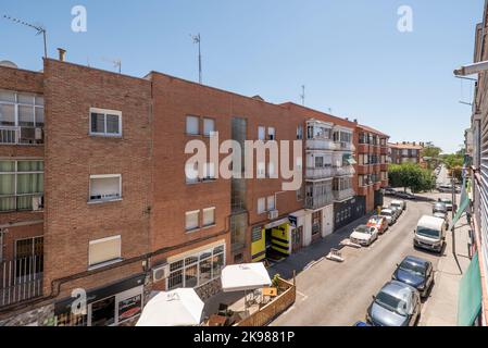 Façades de bâtiments résidentiels urbains en briques modestes avec balcons et de nombreux arbres verdoyants sur la rue Banque D'Images