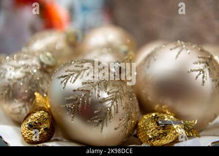 Un groupe d'ampoules en verre d'arbre de Noël rondes de couleur or avec paillettes en forme de feuilles. Les boules de vacances traditionnelles ou les boules de différentes tailles. Banque D'Images